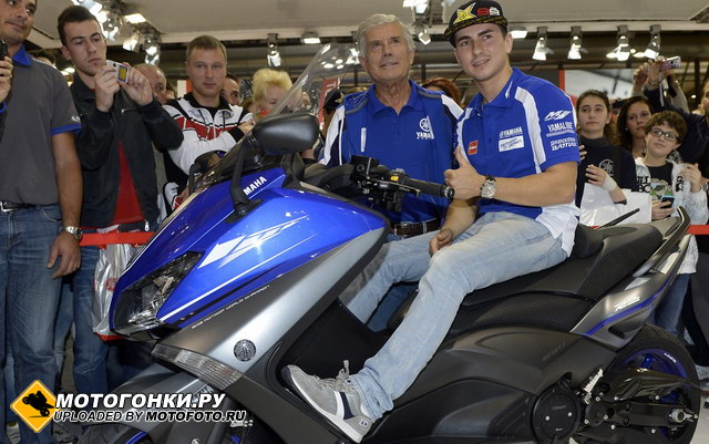 Чемпион 2012 года Хорхе Лоренцо на стенде Yamaha на EICMA вместе с Агостини