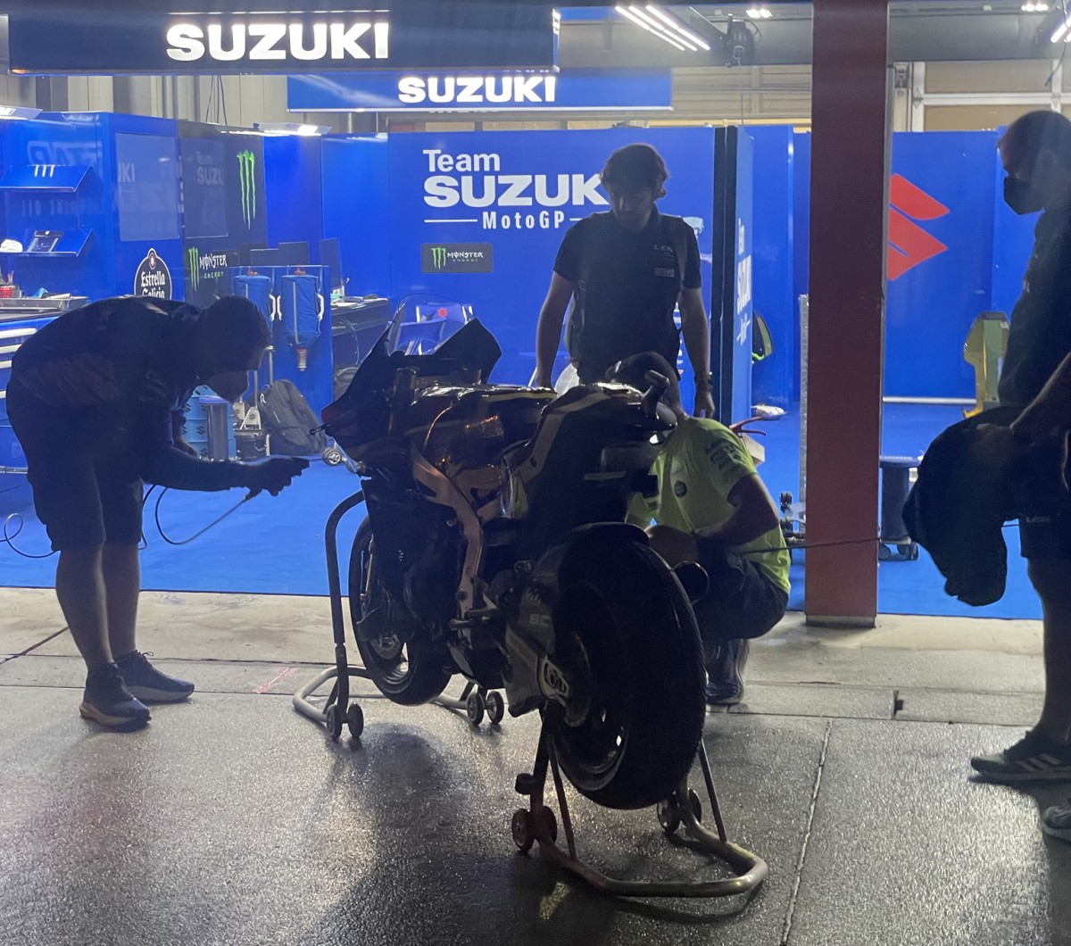 Мехники Suzuki помогают коллегам отчистить мотоциклы после тушения пожара в боксе Marc VDS Racing